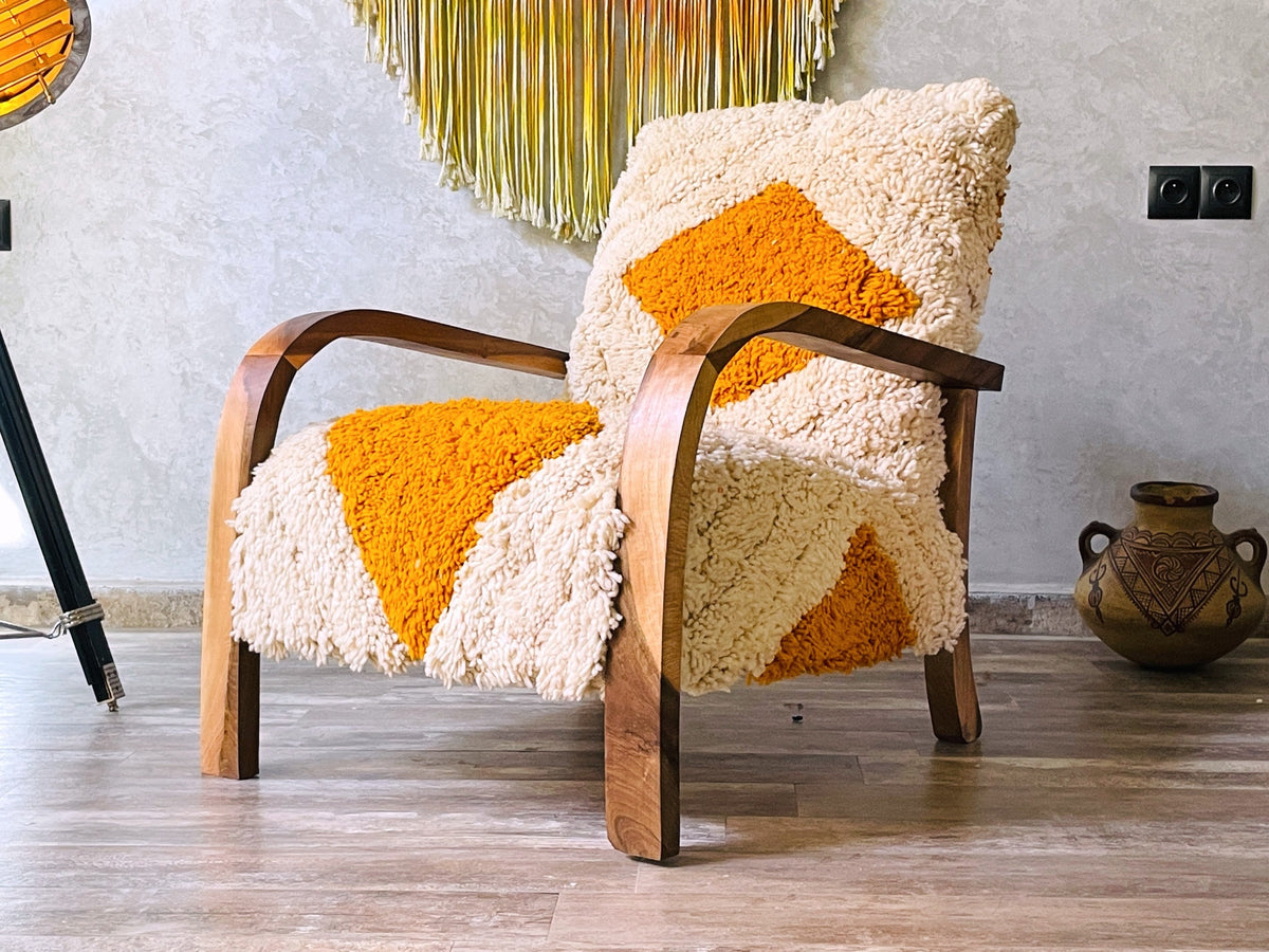 Handcrafted Moroccan mid-century lounge chair with a walnut wood frame and yellow-and-cream checkered wool upholstery in a modern room.